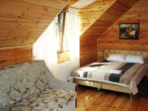 1 dormitorio con 1 cama y 1 silla en una cabaña en Pershyi Kordon Tourist Complex, en Medvedevka 32 fotos más