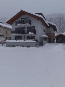 un edificio con nieve en el suelo delante de él en Pension Baldauf - Dorf 31 en Kleinarl