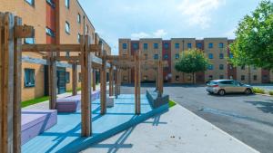 a playground in a parking lot next to a building at Homely Private Bedrooms at Oxford Court in Manchester in Manchester