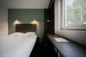 KruishoutemにあるTravel Hotel Kruisemのベッドルーム(白いベッド1台、窓付)