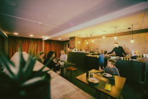 a group of people sitting at tables in a restaurant at Travel Hotel Kruisem in Kruishoutem