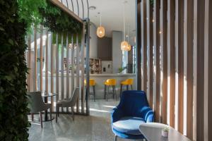 un ristorante con sedia blu, tavoli e sedie di voco Milan-Fiere, an IHG Hotel a Milano