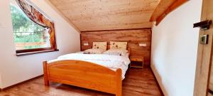 1 dormitorio con 1 cama en una casa pequeña en Chata Oddychovka, en Demänovská Dolina