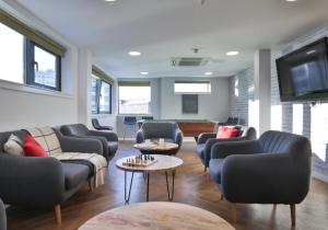 sala de estar con sofás y sillas y TV de pantalla plana. en Stylish Private Bedroom at Parker House in Dundee City Centre, en Dundee