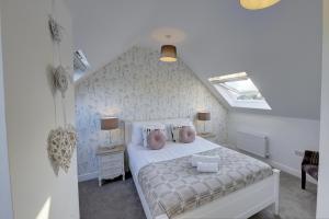 a bedroom with a white bed and a attic at Tunlaw Cottage in Kineton