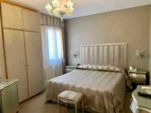 a bedroom with a bed and a chandelier at Hotel Castello in Venice