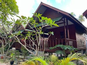 a wooden house with a lot of plants in front of it at Haad Salad Villa in Salad Beach
