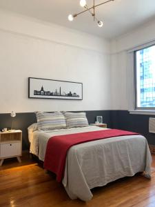 1 dormitorio con 1 cama grande con manta roja en Buenos Aires Downtown Experience #BAExp10 en Buenos Aires
