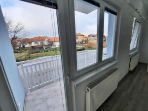 a room with two windows and a view of a street at Apartman San in Bugojno