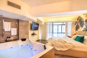 a bedroom with a tub and a bed at Mamilla View- Suites & Apt Hotel in Jerusalem