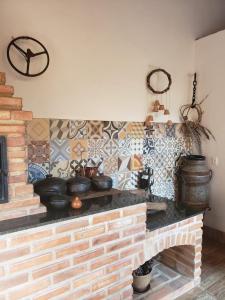Casa Faisão في نوفا ليما: مطبخ مع موقد طوب مع قدور ومقالي