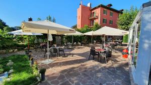 an outdoor patio with tables and chairs and umbrellas at Hostal Ansonea in Bera