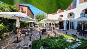 an outdoor patio with tables and chairs and umbrellas at Hostal Ansonea in Bera