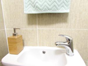 La salle de bains est pourvue d'un lavabo, d'un robinet et d'un mur en carrelage. dans l'établissement Wellness apartments Florenc, à Prague 60 autres photos