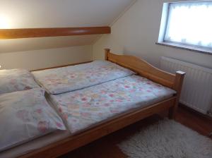 two beds in a small bedroom with a window at Drago Kremenjaš in Delnice