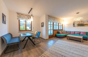 een woonkamer met een bank en een tafel en stoelen bij Ferienwohnung Kogelblick in Ebensee