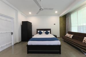 a bedroom with a bed and a couch at Villa cork in Galle