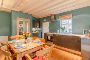 a kitchen and dining room with a wooden table and chairs at 2 Manor Lodge Cottages in Chipping Campden