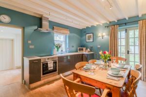 a kitchen and dining room with a table and chairs at 2 Manor Lodge Cottages in Chipping Campden