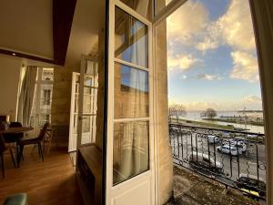 una camera con una grande porta a vetri con vista su un balcone di - Le Saugeron - a Blaye