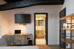 a bedroom with a desk and a tv on the wall at EtxeAundi Hotel Boutique in Oñate