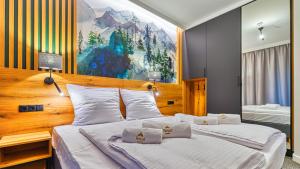 sypialnia z 2 łóżkami i obrazem na ścianie w obiekcie Apartamenty VIP Centrum - Wczasowa 17 by Royal Aparts w Świeradowie Zdroju