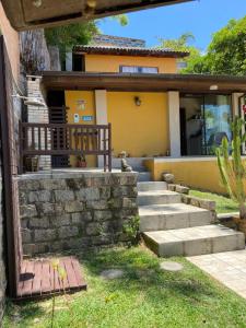 a house with a stone staircase in front of it at Plumeria Guest House in Florianópolis