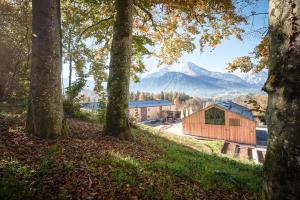 eine Holzscheune mit einem Berg im Hintergrund in der Unterkunft Kulturhof Stanggass in Bischofswiesen