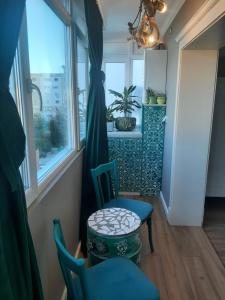 Zimmer mit 2 Stühlen, einem Tisch und einem Fenster in der Unterkunft Restauro Apartament in Buzău