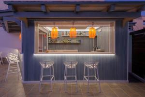 a bar with stools in front of a blue wall at Hotel Boutique Sibarys - Adults Recommended in Nerja