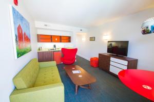 a living room with a couch and a table and a kitchen at Mother Earth Motor Lodge in Kinston