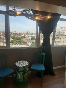 une chambre avec deux chaises et une fenêtre avec vue dans l'établissement Restauro Apartament, à Buzău