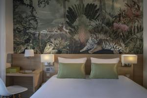 a bedroom with a bed and a painting of tigers at Hotel Chambord in Menton