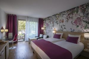 a hotel room with a bed and a desk and a room at Hotel Chambord in Menton
