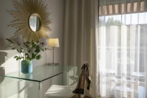 a dressing table with a mirror and a vase of flowers at Hotel Chambord in Menton