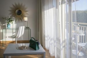 a living room with a chair and a table and a window at Hotel Chambord in Menton