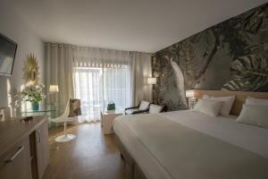 a bedroom with a large bed and a large window at Hotel Chambord in Menton