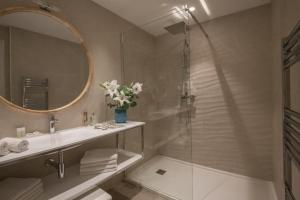 a bathroom with a shower and a sink and a mirror at Hotel Chambord in Menton