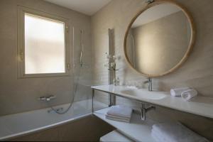 a bathroom with a sink and a mirror and a tub at Hotel Chambord in Menton