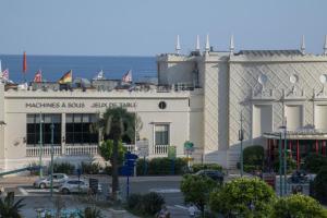 a large white building with the ocean in the background at Hotel Chambord in Menton