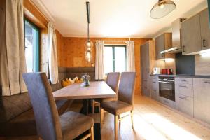 uma cozinha com uma mesa de madeira e cadeiras num quarto em Almliesl WERF-657 em Werfen