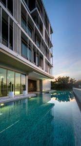 a swimming pool in front of a building at Welladee Wellness Chiang Mai in Chiang Mai