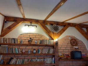 een kamer met boekenplanken en een klok aan de muur bij Casa Marcus in Sighişoara