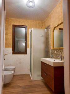 bagno con lavandino, servizi igienici e specchio di B&B Guarini a Casamassima