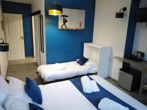 2 camas en una habitación con paredes azules en Les Remparts, en Montreuil-sur-Mer