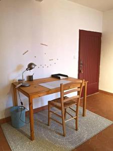 un bureau en bois avec une lampe et une chaise dans l'établissement Maison de charme entre ville et campagne, à Amilly