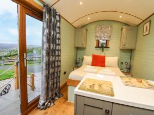 a small bedroom with a bed and a balcony at Highland View in Rhayader
