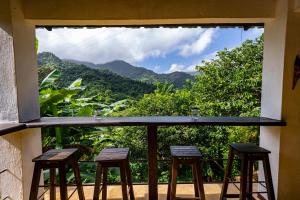 balcón con taburetes y vistas a la montaña en Casa AliBri, en Santa Marta