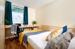 a bedroom with a bed and a desk and a window at iQ Ty Willis House in Bangor 3 Min Walk to Bangor Station in Bangor