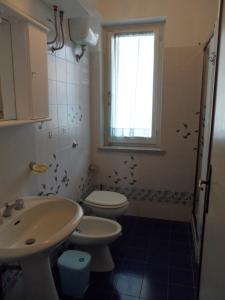 a bathroom with a sink and a toilet and a window at Case Vacanze Valdilago in Bolsena